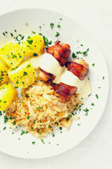 roasted roll of rabbit belly and bacon under mustard based sauce garnished with vegetables