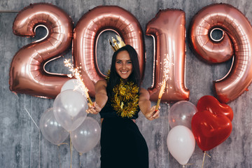 Woman holding balloons looking at camera. Celebration holiday new year