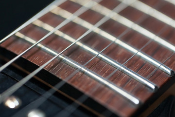 guitar  with wooden brown neck and strings, close up blurry background, texture, abstract