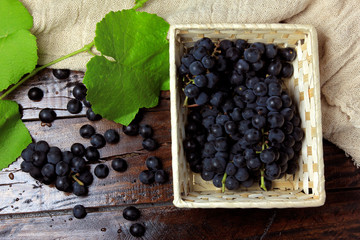 bunches of grapes, inside bamboo fiber basket on wooden table