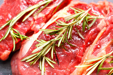Raw beef steak with rosemary. Close-up shot