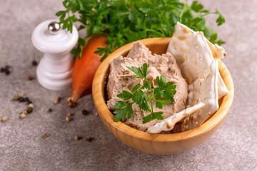 Pieces of matzah with homemade liver pate with parsley and onion on  gray marble background. Horizontal view. Copy space