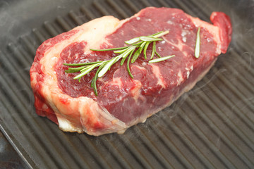 New-York Steak on frying grill panwith rosemary , top view