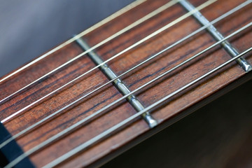 Fototapeta premium guitar with wooden brown neck and strings, close up blurry background, texture, abstract