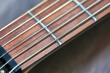 guitar  with wooden brown neck and strings, close up blurry background, texture, abstract