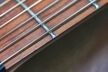 guitar  with wooden brown neck and strings, close up blurry background, texture, abstract