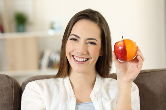 Woman showing an half orange and apple
