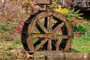 Working watermill wheel with falling water in the village © Oleksandr