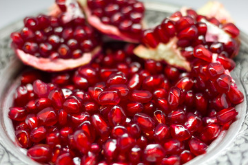 Bright red pomegranate seeds isolated on white background