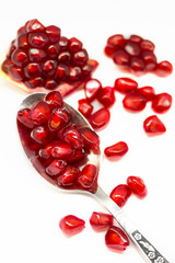 Bright red pomegranate seeds isolated on white background