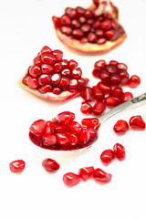 Bright red pomegranate seeds isolated on white background