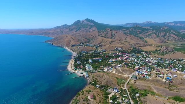 Beautiful sea and reef coastzone mountain range and many of the piers Karadag in Crimea old city, aerial view.