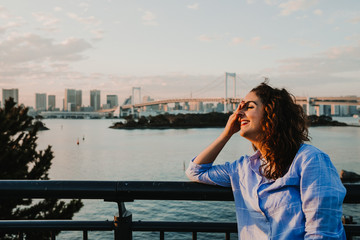 .Beautiful view of Tokyo Bay from the Odaiba district. Happy young woman taking enyoing travelling around Japan. Lifestyle.