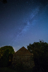 Milky way over old brick and stone building