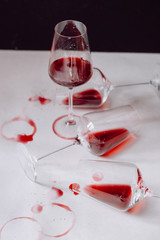 Glasses of spilled red  wine  on white and dark  background,  copy space.  Wine degustation concept