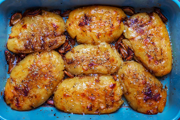 Baked potatoes in baking tray with garlic rosemary and sea salt