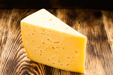piece of cheese on a wooden surface