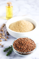 Flax seeds, flax flour, oil with sprouts and flax seed boxes on a light background.