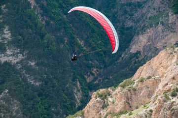 Paraglider flying near high mountains. Chegem. Russia.