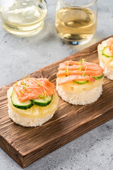 Bruschetta toast of white bread with slices of pineapple cucumber fish salmon fresh green sprouts