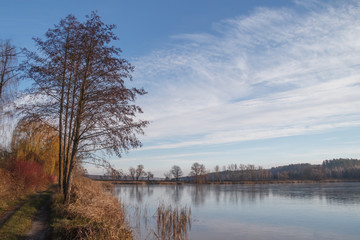 Autumn clouds on a background of blue sky and trees on the shore of a frozen lake