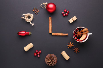 A clock in the form of spice for mulled wine. Cinnamon, anise stars, cranberries, brown sugar. Concept, creative work.