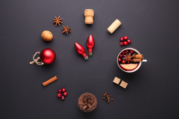 A clock in the form of spice for mulled wine. Cinnamon, anise stars, cranberries, brown sugar. Concept, creative work.
