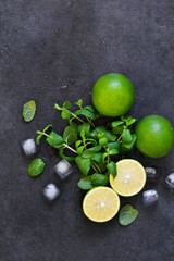 Fresh mint, lime and ice on a black background. Ingredient for mahito. Top view