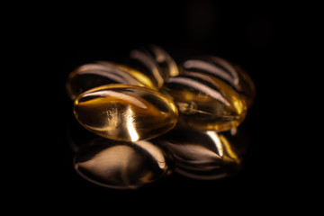fish oil omega 3 gel capsules on black background