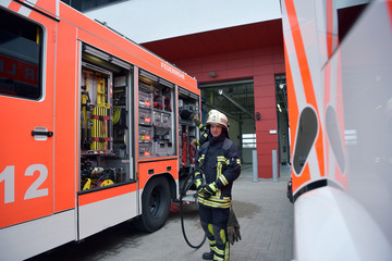 portrait of a firefighter at the emergency vehicle in the fire station