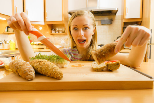 Woman In Kitchen Holding Knife Making Healthy Sandwich