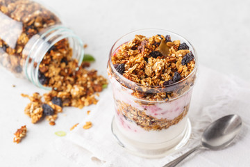 Baked granola, jam and yogurt healthy breakfast parfait in glass.