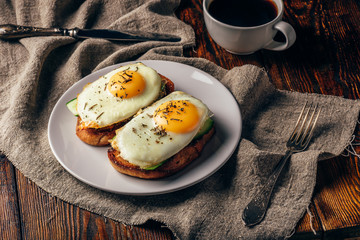 Toasts with vegetables and fried eggs with cup of coffee
