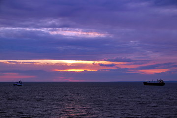 Naklejka na ściany i meble sunset over the sea and the ships sailing away