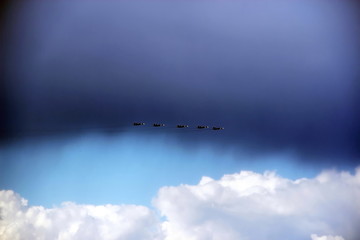 Fototapeta na wymiar five jet fighters in the sky against a rain cloud background