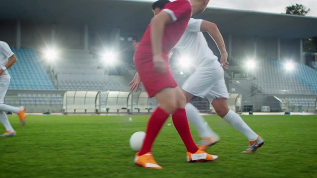 Focus on Legs of a Professional Soccer Player Leading with a Ball, Masterfully Dribbling Around His Opponents. Two Professional Football Teams Playing on Stadium. Low Angle Ground Shot.