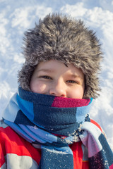 Adorable smiling boy at the snow background