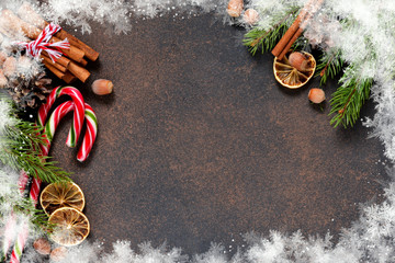 Christmas tree with cinnamon, nuts, candy on a brown background with space under the text.