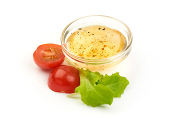 Cup with salad dressing with Fresh lettuce and sliced juicy tomato, isolated on a white background. Close-up.