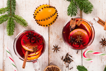 Christmas hot mulled wine with spices on wooden background.