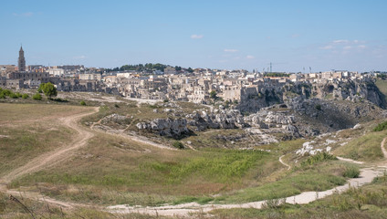 Fototapeta na wymiar Houses built into the rock in the cave city of Matera, Basilicata Italy. Matera has been designated European Capital of Culture for 2019. Photographed from inside a cave in the ravine opposite.