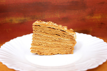 piece of honey cake on dark red background
