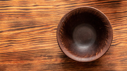 Old clay shabby plate on a yellow wooden table