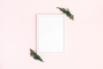 Christmas composition. Photo frame, fir tree branches on pastel pink background. Christmas, winter, new year concept. Flat lay, top view, copy space