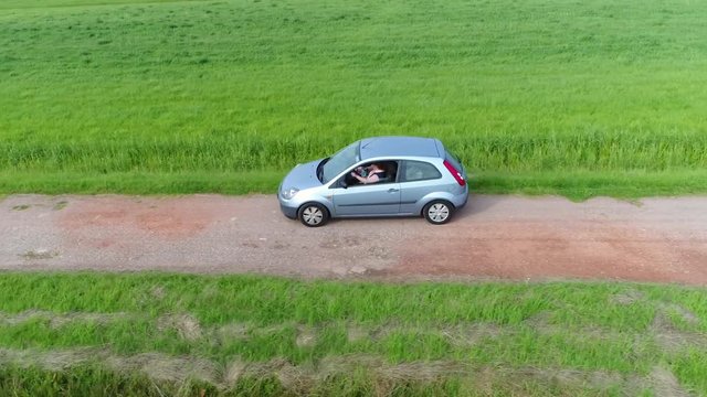 Aerial footage following vehicle which drives over gravel path also passing by ongoing travel on the narrow way compared to sealed roads these are easy and cheap to build 4k high resolution quality