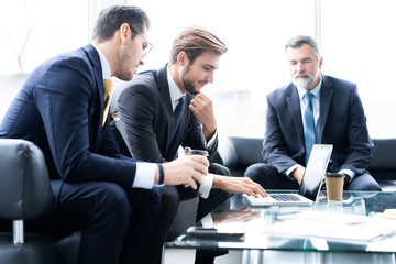 Group of business partners discussing ideas and planning work in office.