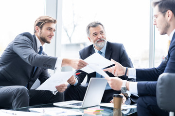 Group of business partners discussing ideas and planning work in office.