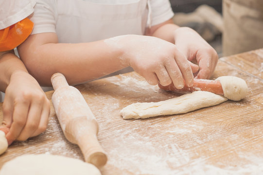 Young children make sausage dough. Hands closeup
