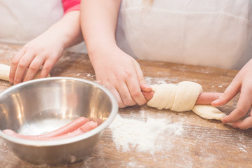 Obraz na płótnie Canvas Young children make sausage dough. Hands closeup