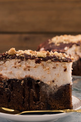 Chocolate cake. Close up. White and brown layer. Vertical. Wooden background.